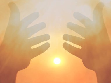 Güneşin arka planında iki el. İki erkek eli arasındaki güneş ışığı. güneşli gökyüzü arkaplanı