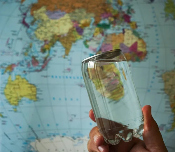 Plastová Plechovka Čistou Pitnou Vodou Pozadí Mapy Zeměkoule Transparentní Láhev — Stock fotografie