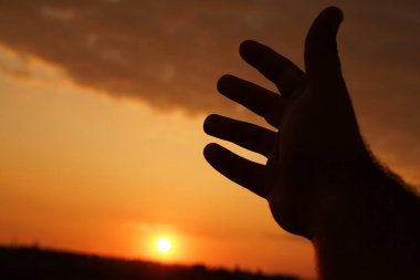 Adam rüyasında elini güneşe uzatıyor.