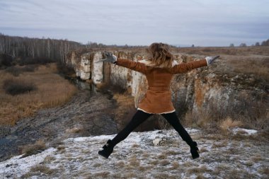 Karla kaplı arka planda zıplayan lüks bir kadın.