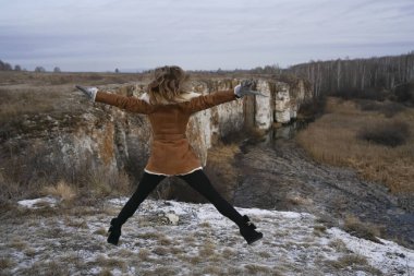 Karla kaplı arka planda zıplayan lüks bir kadın.