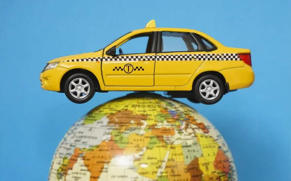 Жовтий Автомобіль Таксі Модель Металевої Іграшки Глобусі Ізольовано Синьому Фоні — стокове фото