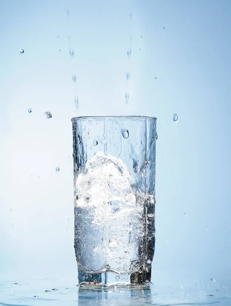 water splash in glass  isolated on blue background.