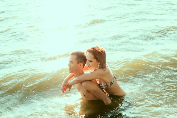 Sexy kiss in hot water. passionate couple in sitting in sunset sea shore or ocean. perfect body and sporty couple. man and woman outdoors. empty copy space for inscription. couple in love. summertime season