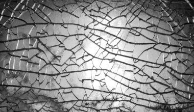 Kırık bir cam pencerenin açık hava görüntüsünü kapatın. Vandalizmin ve hasarın soyut görüntüsü.