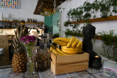 Tahta kutuda muzlar ve vejetaryen kafede masada ananas. Buddha heykeli yanan mumla