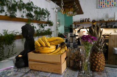 Tahta kutuda muzlar ve vejetaryen kafede masada ananas. Buddha heykeli yanan mumla