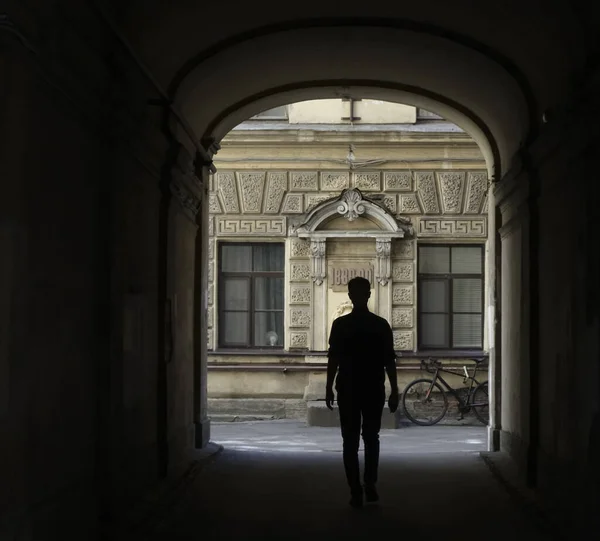 歴史的建造物への扉 放棄された建物の中の暗い廊下の端の男 幽霊の建物の中に恐ろしい景色 サンクトペテルブルク — ストック写真