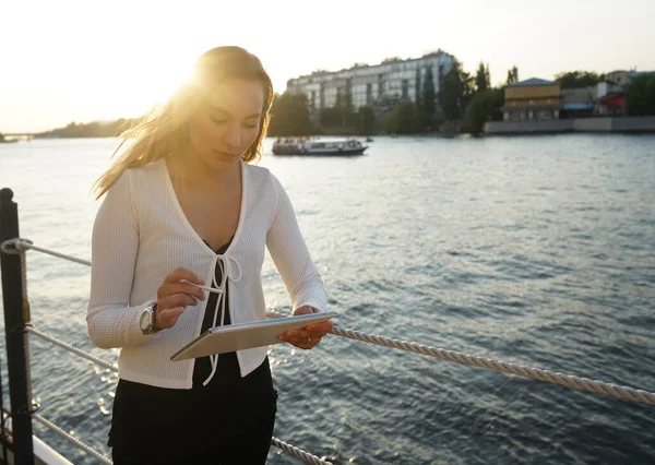 Yazlık Kıyafetli Ciddi Bir Kadını Sahilde Duruyor Kalemle Tablet Kullanıyor — Stok fotoğraf