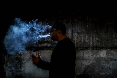 Siyah arka planda sigara içen bir adamın silüeti