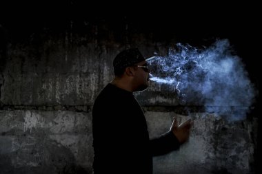 Siyah arka planda sigara içen bir adamın silüeti