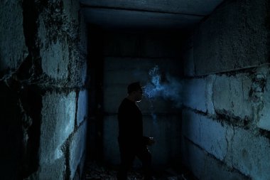 Siyah arka planda sigara içen adamın silüeti.