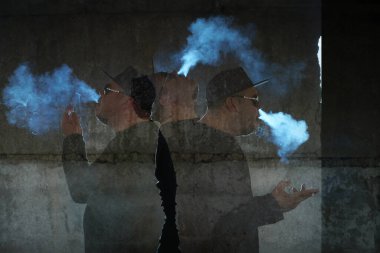 Siyah arka planda sigara içen adamın silüeti.