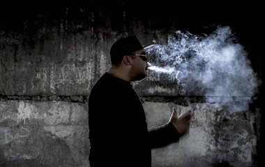 Siyah arka planda sigara içen bir adamın silüeti