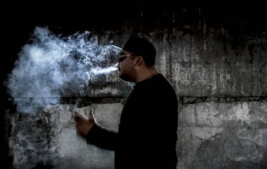 Siyah arka planda sigara içen bir adamın silüeti