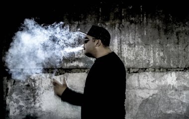 Siyah arka planda sigara içen bir adamın silüeti