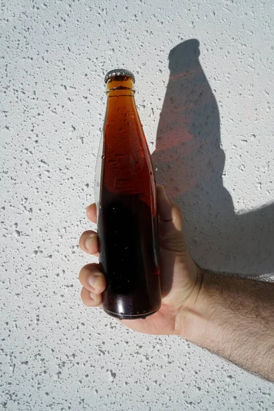 Botella Cola Transparente Vidrio Mano Masculina Sobre Fondo Pared Blanco — Foto de Stock