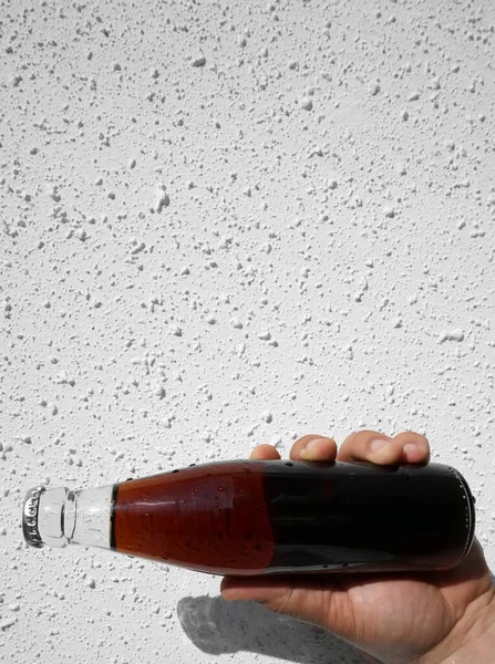Bottiglia Cola Trasparente Vetro Mano Maschile Sfondo Bianco Luce Ombra — Foto Stock