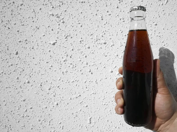 Man Hand Hålla Glas Genomskinlig Flaska Cola Vit Vägg Bakgrund — Stockfoto