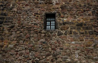 Demir ızgara ve ahşap pencere çerçeveli eski taş duvar. dış arkaplan. 