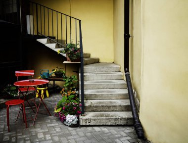 Kasaba evlerinin güzel manzarası. Üzerinde bir sürü çiçek saksısı olan merdivenleri olan eski bir taş ev. Evin bahçesinde bir oturma masası var. Summer Caddesi Kafe 'si. Saint Petersburg, Rusya. 