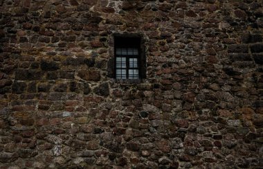 Demir ızgara ve ahşap pencere çerçeveli eski taş duvar. dış arkaplan. 