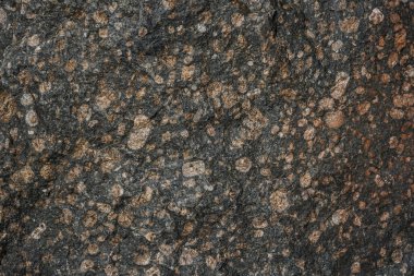 Kahverengi desenli kaya blokları. Maden kayalıkları engebeli yüzey. Sert kireçtaşı taş ocağı arka planı. Ağır grunge doğal duvar zeminine zarar vermiş. Tasarım için antik ortaçağ mermeri ön cephesi 