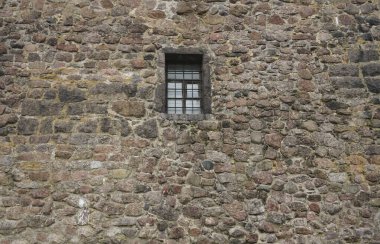 Demir ızgara ve ahşap pencere çerçeveli eski taş duvar. dış arkaplan. 