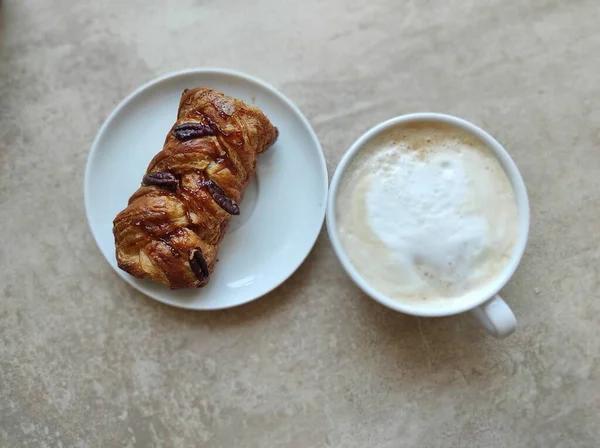 Cappuccino dans une tasse blanche avec pacane d'érable sur une soucoupe — Photo