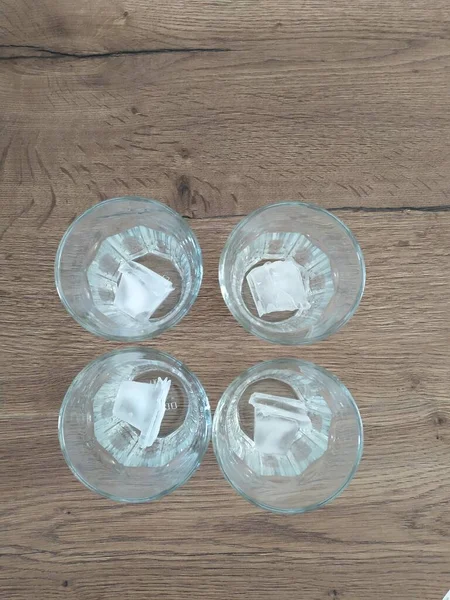 Quatre verres de glace vides sur une table en bois — Photo