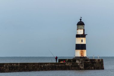 Seaham 'da fenerde balık tutan bir adam var.