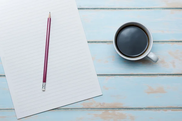 Kaffee mit Notizbuch und Bleistift auf blauem Himmelsholzboden. — Stockfoto