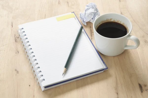 Notebook és a kávé, a fából készült háttér. — Stock Fotó