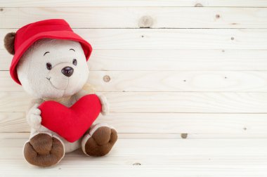 Unutmayın ki aşk aşınma kırmızı şapka kırmızı kalp ahşap arka plan üzerinde tutun..