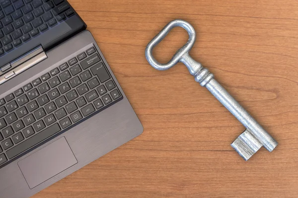 Starý velký klíč a laptop — Stock fotografie