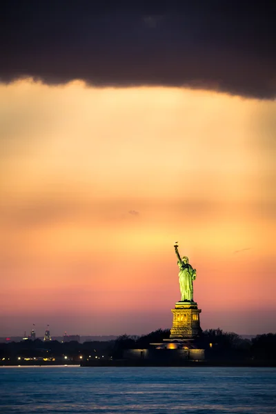 Άγαλμα της ελευθερίας, κάτω από μια δραματική ηλιοβασίλεμα φως — Φωτογραφία Αρχείου