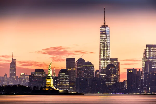 Lower Manhattan und die Freiheitsstatue bei Sonnenaufgang lizenzfreie Stockfotos
