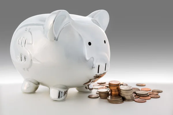 Piggy bank and a pile of coins — Stock Photo, Image