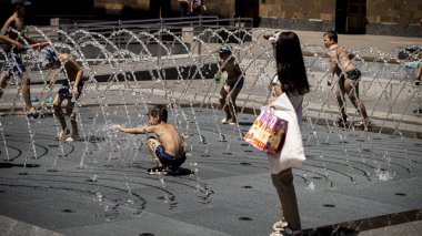 Çocuklar meydandaki çeşmede yıkanıyor..