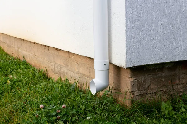 Witte kunststof downpipe op de hoek van een nieuw huis Rechtenvrije Stockafbeeldingen