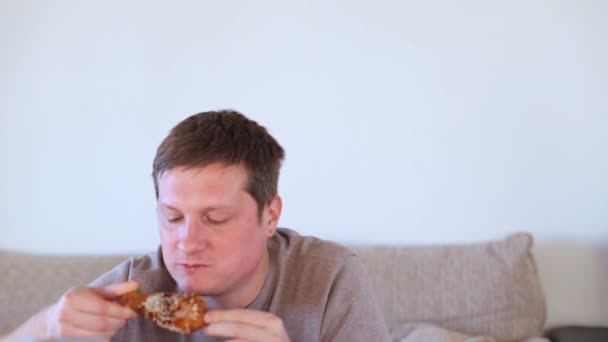 Чоловік їсть нездорову їжу з апетитом. Продукти з високим вмістом вуглеводів, жирів . — стокове відео