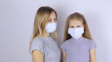 Koruyucu tıbbi maskeli kadın ve kız.