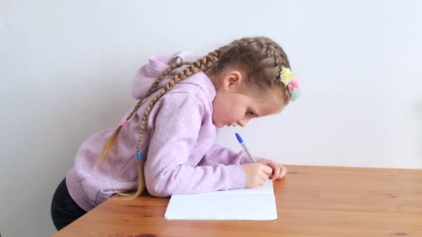 Enfant faisant ses devoirs à table — Video