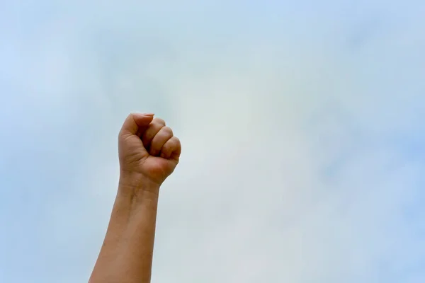Puño apretado contra el cielo azul. Mujeres mano de la independencia y la libertad de la violencia —  Fotos de Stock