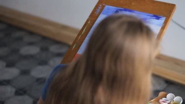 Anaokulundaki bir kız şövaleye resim çizer.