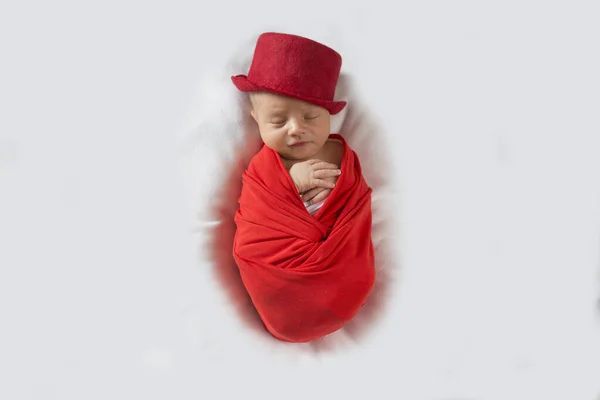 Bebé recién nacido durmiendo dulcemente con un sombrero de copa rojo. Lindo bebé recién nacido en un traje rojo y sombrero. —  Fotos de Stock
