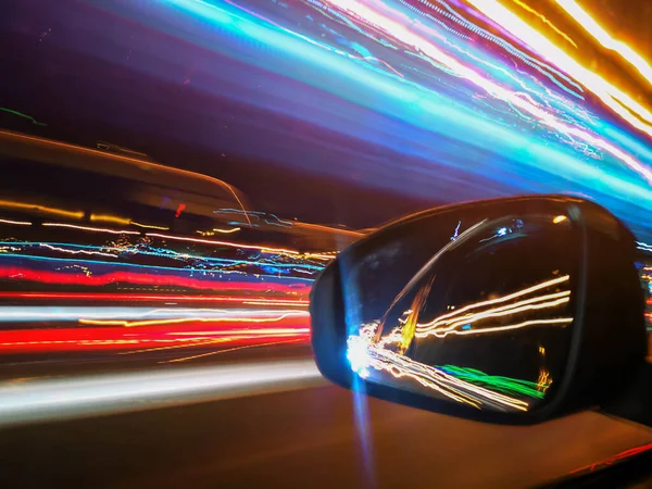 Corsie al neon e auto riflesso nello specchio retrovisore — Foto Stock