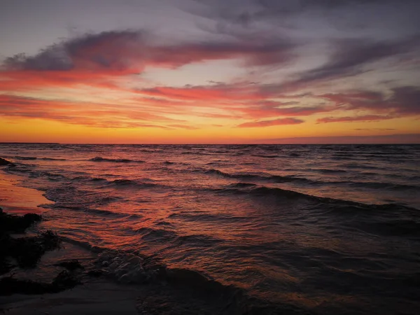 Red, orange, yellow sunset reflecting in stormy Baltic Sea — Stock Photo, Image