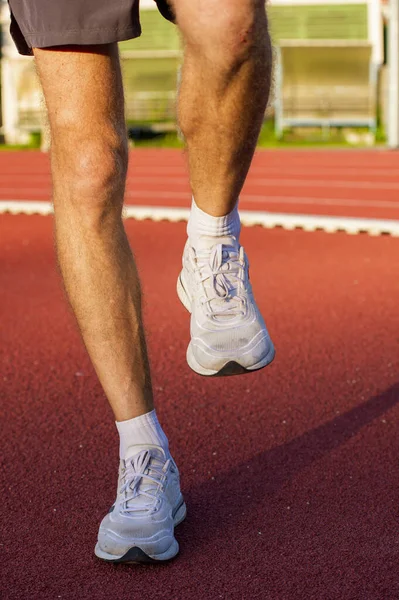 Man athlete getting ready to run warming up muscles of legs — Stock Photo, Image