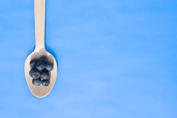 Recycled spoon and juicy, fresh blueberries on color table — Stock Photo, Image